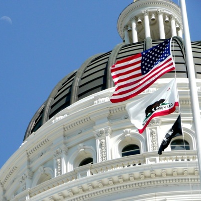 picture of the CA State Capitol building with flags